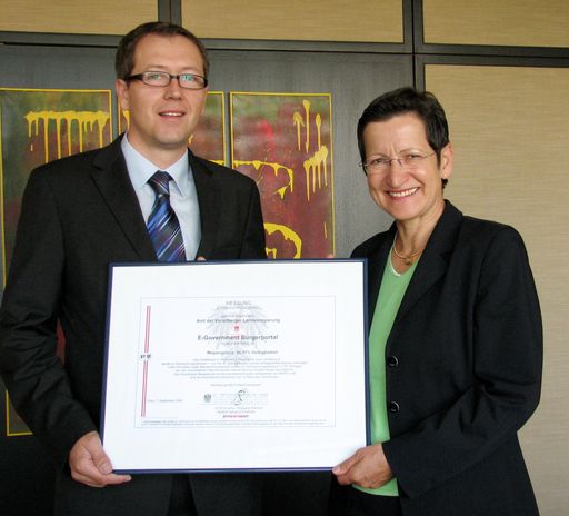  IT-Ziviltechniker DI Dr Prentner überreicht der Vorarlberger Landesrätin Dr. Greti Schmid das staatlich anerkannte E-Government Monitoring Zertifikat als Beleg für die hervorragende Verfügbarkeit der Internetdienste des Amtes der Vorarlberger Landesregierung