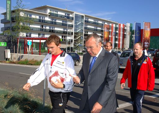 Bundeskanzler Alfred Gusenbauer begleitet das Team der österreichischen U20 Fußball-Nationalmannschaft auf dem kurzen Weg vom Hotel zum Trainingsgelände. Im Hintergrund der Gebäudekomplex von "Harry’s Home".