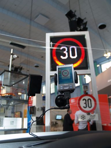 Das Signalbild eines Wechselverkehrszeichens wird mittels Infrarot-Technik auf den PDA ins Fahrzeug übertragen und gibt so ständige Orientierung z.B. über Geschwindigkeitsbeschränkungen auf Straßenabschnitten. Das Cockpit im Bild wurde von MAGNA zur Verfügung gestellt, die C2X-Technologie kommt aus dem Hause EFKON, das Wechselverkehrszeichen von SWARCO.