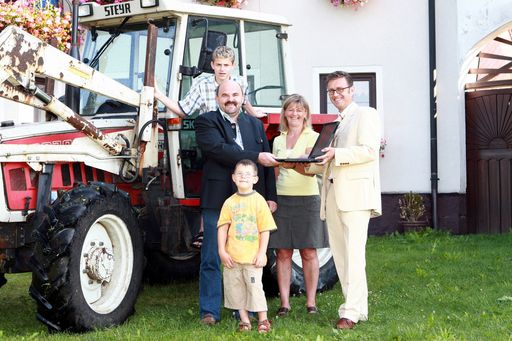 Peter Allerstorfer, Leiter der Telekom Austria Shops, gratuliert der Familie Sinzinger als 600.00ster Breitband-Kunde mit einem Laptop.