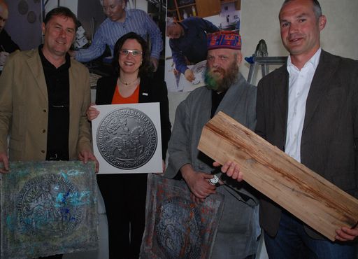 Vorschau Bild von Der in Wien lebende und aus Hall stammende Künstler Prof. Ernst Friedrich stellt auch mit der künstlerisch und aus 500 Jahre altem Holz gestalteten Verpackung, historische Bezüge dar. (v.li.:) Dr. Christian Margreiter und Mag. Bettina Haas (TVB Region Hall-Wattens), der Künstler Prof. Ernst Friedrich sowie Andreas Ablinger (Münze Hall).