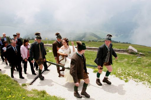 Vorschau Bild von Kaiserliche Bergtour wie vor dem Bau der SchafbergBahn. Sisi Darstellerin Maya Hakvoort wurde von vier Sesselträgern zu ihrem glanzvollen Gastauftritt auf der Schafbergspitze getragen. (Auf einem originalen Stuhl von Erzherzogin Sophie.) Im Geleit politische Prominenz von Salzburg und Oberösterreich.