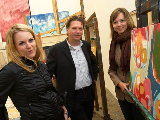 Vorschau Bild von Die Malerinnen Ingrid Mauthner und Selina Saranova sowie Organisator Peter Doujak bei den Vorbereitungsarbeiten für die Vernissage.