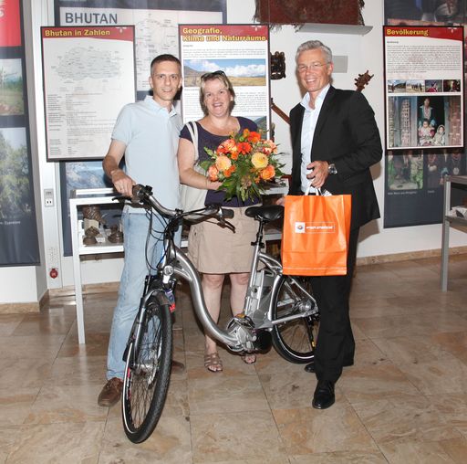 Bildtext: Angelika Riedl ist die 900.000ste Besucherin des Wien Energie-Hauses. Ihr Mann Erich (l.) und sie wurden am 25.8. 2010 von Wien Energie-Geschäftsführer Robert Grüneis (r.) mit einem Elektrofahrrad und einem Blumenstrauß überrascht.