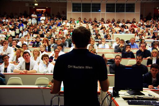 Vorschau Bild von Stefan Konrad, Vorsitzender der ÖH Medizin Wien spricht zur.Vollversammlung, an der Studierende, Professoren, Mittelbau und das.Rektorat teilnehmen..