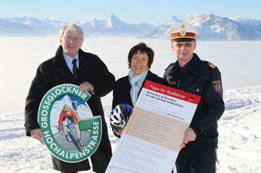 GD Dr. Christian Heu (GROHAG), Mag. Ursula Hemetsberger (KfV), Oberst Friedrich Schmidhuber (Polizei, Verkehrsabteilung) mit Sicherheitskarte, Radlerhelm und "Radfahrer-Pickerl".