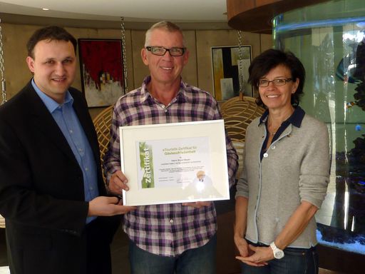 Michael Egger - Inhaber von eTouristik, Erich und Andrea Mayer vom Hotel Alpenrose in Lermoos freuen sich über das verliehene Zertifikat für Gästezufriedenheit