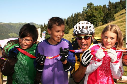  Bike-Legende Richie Schley aus Kanada sorgte am Samstag dem 9. Juli gemeinsam mit den Downhill-Kids der Region beim Start der Strecke für das offizielle "Durchbeißen des Schoko-Bandes".