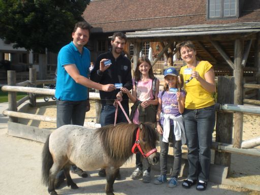 Seenland-Tourismus-Geschäftsführer Mag. Werner Redl überreicht Familie Priechenfried aus Linz, eine Seenland Card auf Gut Aiderbichl