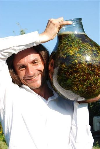  Robert Rogner jun. mit einem Glasballon, in dem die Vollsonnenölauszüge heranreifen.