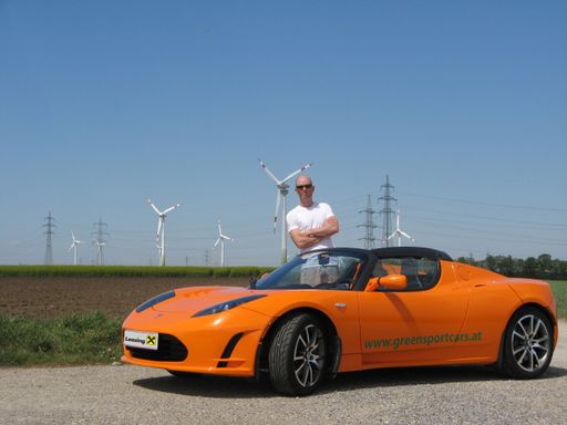 Manfred Hillinger mit dem von Raiffeisen-Leasing finanzierten Tesla vor einem Windpark