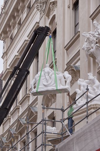  Platzierung der Sandstein-Figur des Feuergottes Vulkan auf dem Balkon über dem Hauptportal des STADTPALAIS Liechtenstein