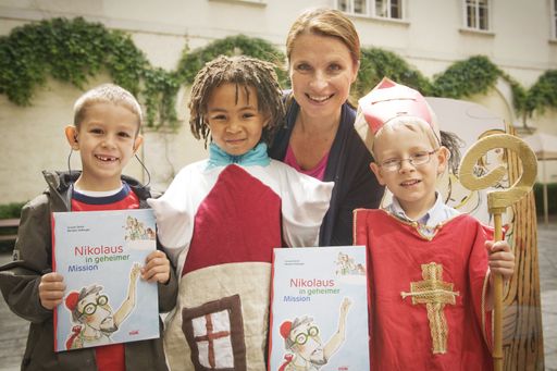 Moderatorin Barbara Stöckl mit den Kindern der Stiftungskindergärten St. Nikolaus und dem Buch