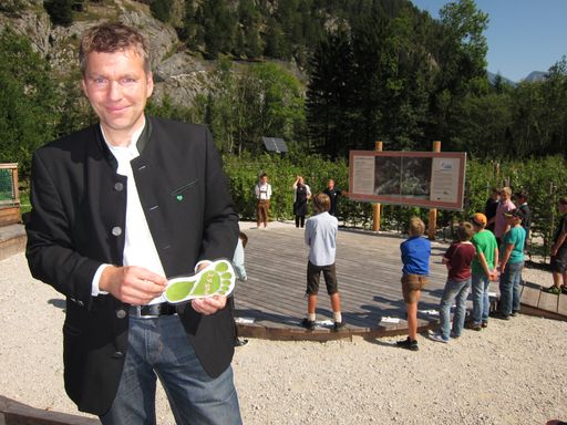 Vorschau Bild von DI Martin Hartmann, MSc von der Nationalpark
Gesäuse GmbH mitten im begehbaren ökologischen Fußabdruck. Das
Projekt umfasst einen 70 Meter langen Informationsparcours, der vor
allem bei Jugendlichen sehr gut ankommt und das Bewusstsein für den
eigenen ökologischen Fußabdruck schärft.