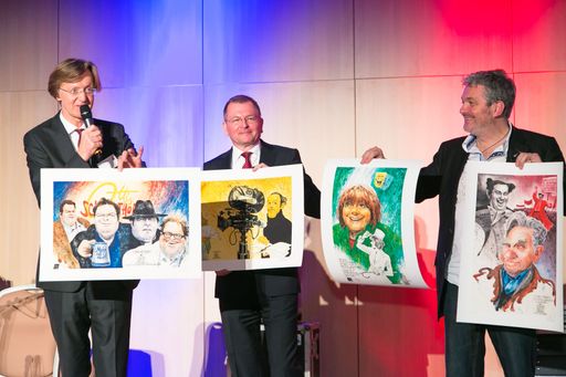 Vorschau Bild von Projektleiter Mag. Helmut Kuchernig, GM Johannes
Mauthe aus dem Savoyen und Werner Brix präsentieren die Karikaturen
von Oliver Schopf
