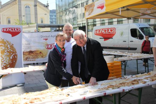 Mit dem Anschnitt des 120 Meter langen
Dinkel-Apfelstrudels durch den Linzer Bürgermeister Franz Dobusch
(rechts) gemeinsam mit Firmeninhaber Reinhard Honeder (Mitte) und
Helga Honeder, begann am 13. Juni 2013 ein stimmungsvolles Fest der
Honeder Naturbackstube am Martin-Luther-Platz in Linz.