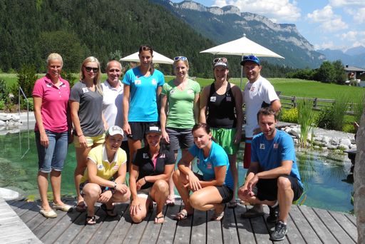 Vorschau Bild von Die Athletinnen und Trainer am Badeteich des
Glückshotels