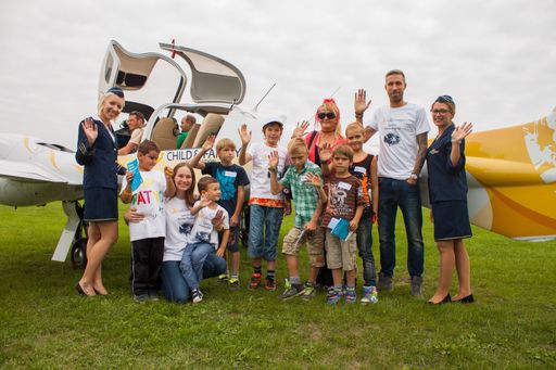 Freudige Erwartung bei den Kindern vor dem Rundflug
SK-Sturm Spieler Patrick Wolf (rechts) Direktorin der Lyoness Child
& Family Foundation Nina Passegger (links hockend)