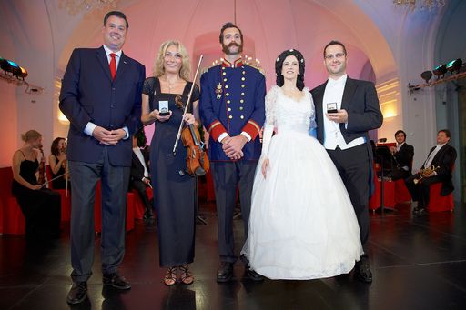  http://www.apa-fotoservice.at/galerie/4672 Beim
6000. Konzert: (v.l.n.r.) Peter Hosek, Konzertmeisterin Tanja
Sallustio, "Franz Joseph & Sissi", Dirigent Laszlo Gyüker