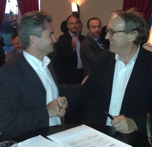 Michel Emelianoff (linke Seite) und David Winn
reichen sich die Hände über dem unterzeichneten
Partnerschaftsvertrag.