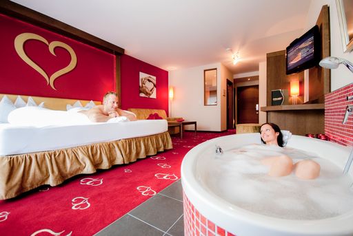  Edles Holz, feine Stoffe und rote Farben mit goldenen Herzmotiven
geben den Herz-Zimmern das äußerst romantische Ambiente. Das
beleuchtete Kuschelbett garantiert himmlische Träume und die
Badewanne vor dem Bett lädt zum Entspannen ein. 40 m2 Wohnfläche.