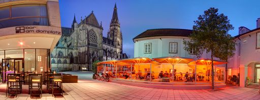 Vorschau Bild von Vor der beeindruckenden Kulisse des Linzer
Mariendomes: paul's küche.bar.greisslerei und das 4 Sterne Hotel am
Domplatz.