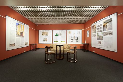 Vorschau Bild von Einer der Ausstellungsräume in der Galerie der
Österreichischen Werkstätten. Das Bild zeigt originale
Jugendstilmöbel im restaurierten Zustand sowie Infotafeln im
Hintergrund zu Leben und Werk von Josef Hoffmann.