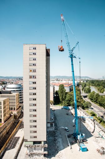 Vorschau Bild von Am künftigen Standort von TrIIIple wird der sogenannte „fliegende
Bagger“ mit einem der größten Autokräne Österreichs für den Abriss
des ehemaligen Zollamts in Position gebracht.