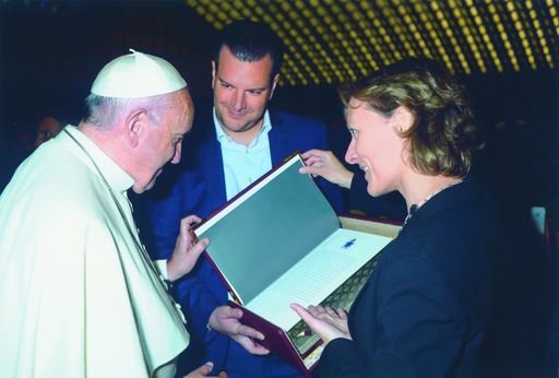 Vorschau Bild von Charlotte Kramer, Michael Kriegler mit Papst
Franziskus werfen einen ersten Blick in die goldene „Bilderbibel der
Barmherzigkeit“.