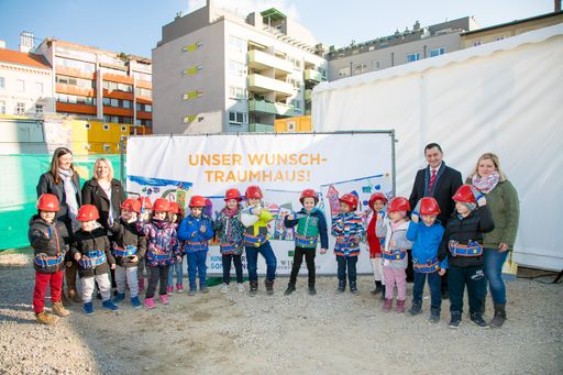 Vorschau Bild von Im Rahmen der Spatenstichfeier der Jägerstraße 58
enthüllt Bezirksvorsteher Hannes Derfler (Brigittenau) gemeinsam mit
Nicole Yildirim (Geschäftsführerin des Kindergartens Sonneninsel)
und den Kindern und Betreuerinnen des Kindergartens Sonneninsel ein
Plakat, auf dem die Kinder ihre Vorstellung eines Wohn-Traumhauses
gemalt haben.