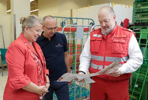 Sozialministerin Beate Hartinger-Klein im Gespräch
mit Mitarbeitern des Roten Kreuzes, die die Ausgabe der
Schulstartpakete abwickeln.