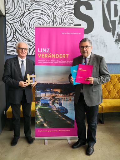 Vorschau Bild von Manfred Grubauer, Vorsitzender des
Tourismusverbandes Linz, (l.) mit dem EU-Award und Tourismusdirektor
Georg Steiner freuen sich über den Nächtigungsrekord.
