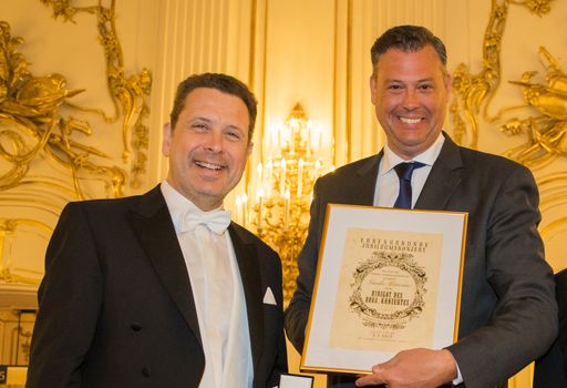 Vorschau Bild von Maestro Guido Mancusi und Peter Hosek auf der Bühne
mit einer Erinnerungsurkunde