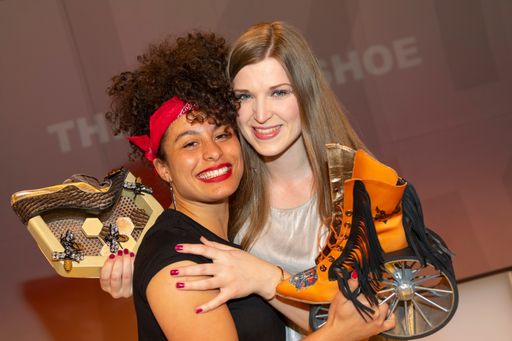Vorschau Bild von Zwei Siegerinnen: Julia Suppanz (rechts) gewann im
Vorjahr den „Award for the Crazy Shoe“, hier mit ihrem prämierten
„Queen Bee“-Schuh von 2018. Sie freute sich mit Paloma Wich (links),
die heuer den ersten Platz mit ihrem Design namens „Harley Davidson“
erreichte. Beide besuchen derzeit die Schuhfachschule Pirmasens in
Deutschland.