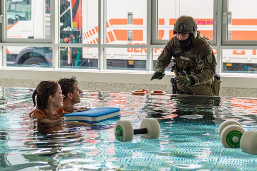 Ein Mitarbeiter der Polizei beim Bergen aus dem
Schwimmbad)