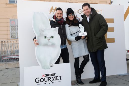 Vorschau Bild von Andi Moravec, Maggie Entenfellner und Daniel
Serafin (v.l.n.r.) mit Gourmet Katze vor der Smile-Wall