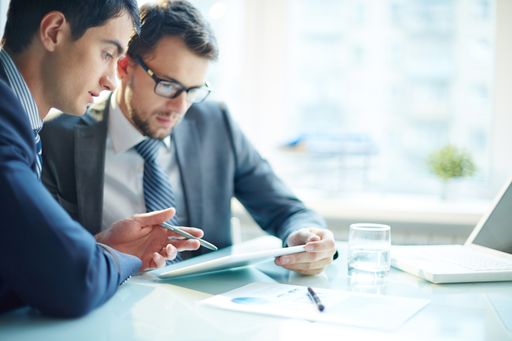  Two business partners working in team and using
computer at the table