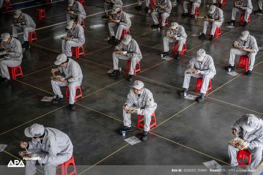 This photo taken on March 23, 2020 shows employees
eating during lunch break at an auto plant of Dongfeng Honda in
Wuhan in China's central Hubei province. Credit:
STR/AFP/picturedesk.com