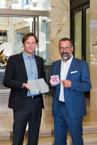 Sebastian Spaun (links) und Rudolf Zrost (rechts)
zeigen anhand eines Probewürfels die Carbonatisierung von Beton.