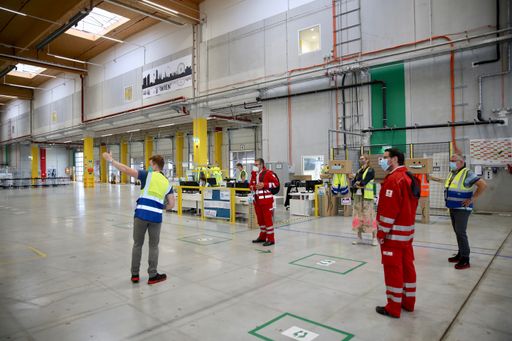  Bernhard Völkl und Peter Klein von Amazon führen
Andreas Fuhrmann, Fanny Tamussino und Florian Rupprecht vom
Österreichischen Roten Kreuz durch das Verteilzentrum Großebersdorf