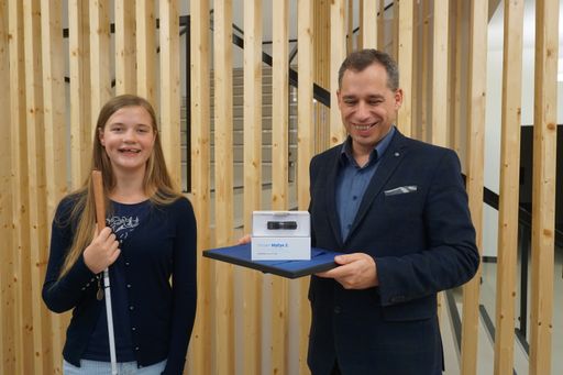 Vorschau Bild von VIDEBIS-Geschäftsführer Christian Zehetgruber
überreicht stellvertretend für Lionel Messi eine OrCam MyEye 2.0 an
Valentina Baier