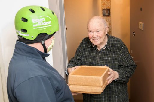 Karl Fellinger, Zusteller des Samariterbund Wiens
(li.) bringt Herrn Hellmut Müksch das Essen auf Rädern.