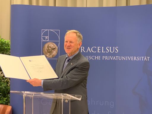 Rektor Prof. Wolfgang Sperl mit der Urkunde