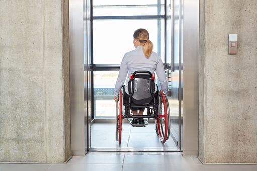 Vorschau Bild von Businesswoman in a wheelchair drives with the
elevator in the business company Gerade in einer alternden und
urbanen Gesellschaft wie der unseren, wird Barrierefreiheit immer
wichtiger. Sie garantiert, dass auch Menschen mit eingeschränkter
Mobilität Aufzüge nutzen können