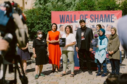 Vorschau Bild von Vor dem Innenministerium wurde bei der Übergabe
eine eigenes gemsachte "Wand der Schande" mit Bildern von
Verletzungen der Geflüchteten aufgestellt.