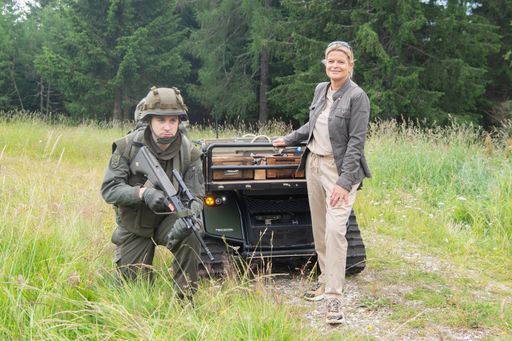 Verteidigungsministerin Klaudia Tanner mit einem
Forschungsroboter, der Soldaten beim Transport unterstützen könnte.