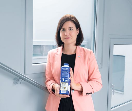 Vorschau Bild von Veronika Breyer, Marketingleiterin der NÖM AG mit
der Packung auf der die Notrufnummer zu sehen ist. ©NÖM AG