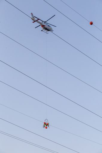 Vorschau Bild von Am Hubschrauber hängend, bis zu 60 Meter über dem
Boden tauschten Leitungsfachmonteure von Heli Austria auf einer
Starkstromleitung der Austrian Power Grid (APG) so genannte
Fliegerwarnkugeln.
