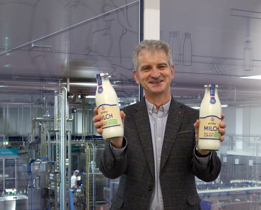 Vorschau Bild von Geschäftsführer DI Josef Braunshofer mit Milch-Mehrwegflaschen
vor einer Abfülllinie