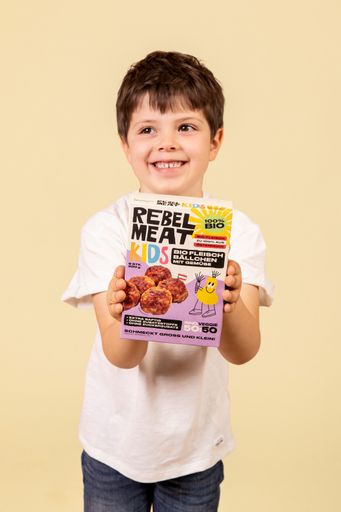 Vorschau Bild von lachender Bub mit Fleischbällchen Verpackung